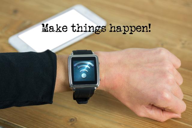 Depiction of human hand wearing a smartwatch with displayed WiFi symbol next to a bright smartphone on a wooden surface. The motivational text 'Make things happen!' overlays the visual. Ideal for tech promotions, productivity campaigns, startup advertising, motivational content, and business presentations.