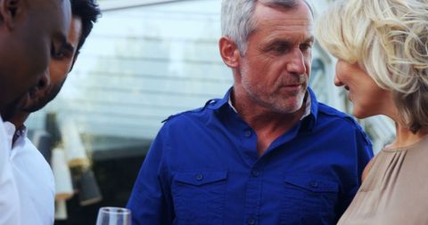 Diverse Group of Adults Engaged in Intense Discussion at Gathering