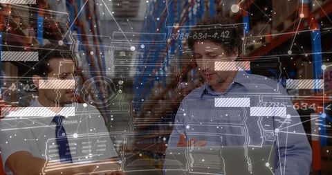 Warehouse colleagues reviewing inventory analytics with AR overlays on laptop
