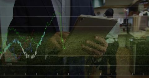 Business Professional Analyzing Financial Charts on Tablet in Office