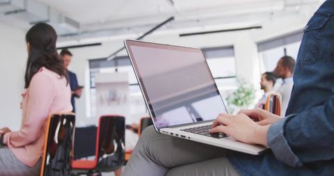 Typing on Laptop in Workshop During Business Presentation and Team Collaboration