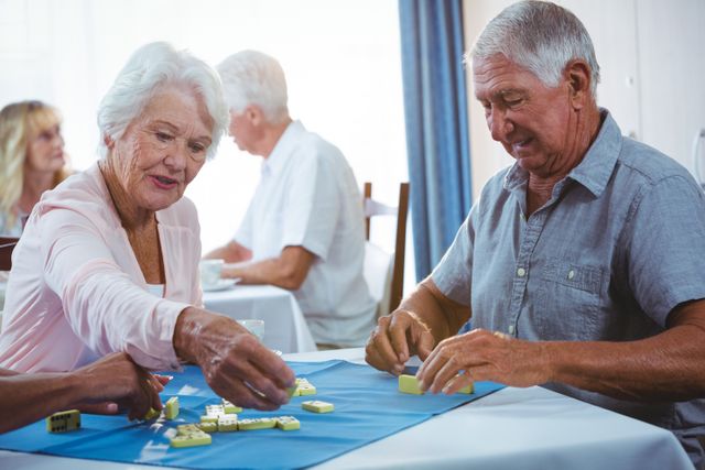 Senior persons enjoy playing domino on a table