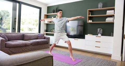Focused Man Practicing Yoga at Home in Modern Living Room