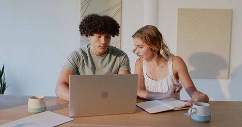Young Professionals Collaborating in Home Office with Laptop