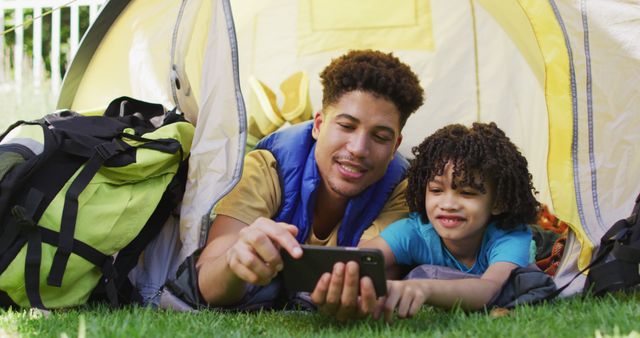 Father and son bonding inside tent during camping trip - Download Free Stock Images Pikwizard.com