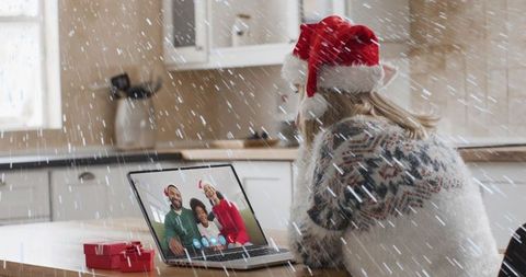 Woman in Santa Hat Video Calls Family Amid Snowy Backdrop