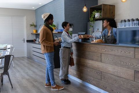 African american customers buying coffee and pastry at modern rustic cafe counter