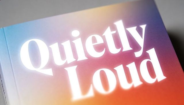 Quietly loud bold serif typography on gradient paperback cover close-up