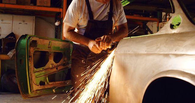 Mechanic Grinding Car Body in Workshop with Sparks Flying - Download Free Stock Images Pikwizard.com