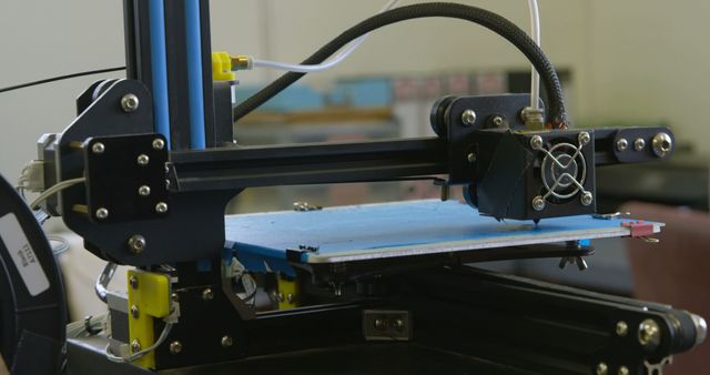 Industrial 3D printer actively printing with a visible print bed. Ideal for illustrating modern manufacturing processes, technological innovation, engineering solutions, and the advanced capabilities of additive manufacturing. Suitable for use in articles, presentations, and marketing materials related to industry, technology, and production.