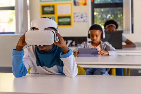 African american students using vr headset and tablets for immersive classroom learning