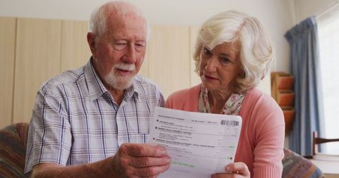 Senior couple reviewing documents at home pandemic concept