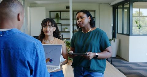 African american women presenting data and collaborating on strategy in modern office
