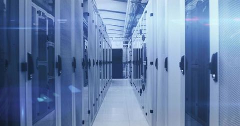 Housing rows of server racks in modern data center corridor with cool blue lighting