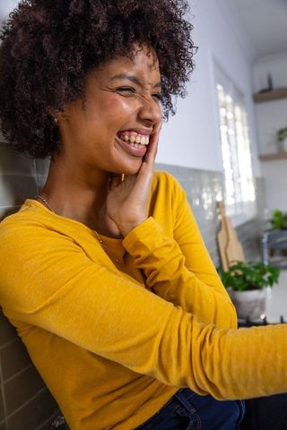 Joyful African American Woman Laughing in Modern Home Kitchen