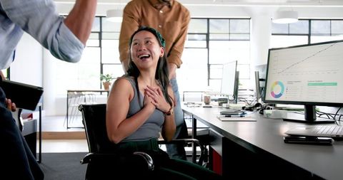 Diverse colleagues enjoying work discussion in modern office