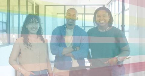 Smiling diverse team standing in modern open-plan office with casual business attire
