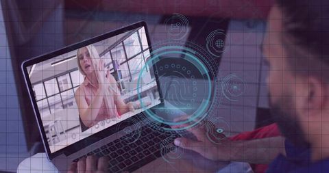 Man following female fitness instructor on laptop with biometric overlay for home workout