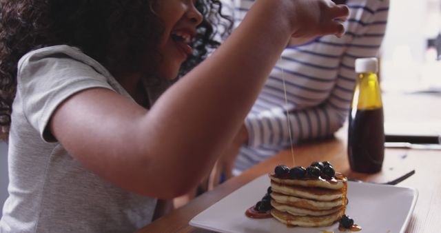 Child Pouring Syrup on Pancakes with Blueberries, Enjoying Breakfast - Download Free Stock Images Pikwizard.com