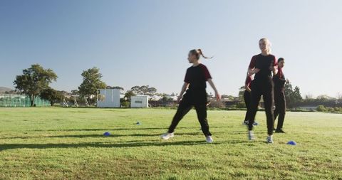 Female Athletes Practicing Drills on Sunny Field