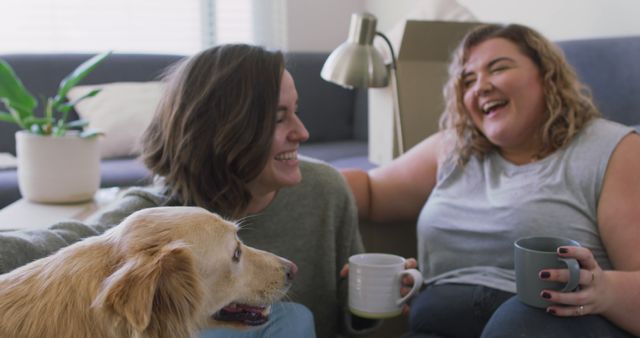 Friends enjoying a joyful moment sitting in a living room, holding coffee cups. A friendly dog sits nearby, adding to the scene's warmth and coziness. This can be used for themes related to friendship, companionship, domestic life, leisure time, and cozy home environments.