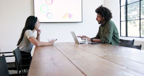 Professionals Discussing Presentations in Modern Office