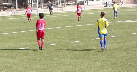 Youth Soccer Game Players Competing on Sunny Day