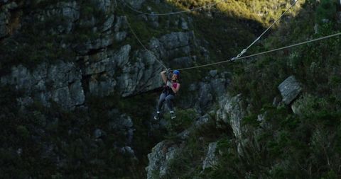 Woman enjoying thrilling zip line across mountain adventure