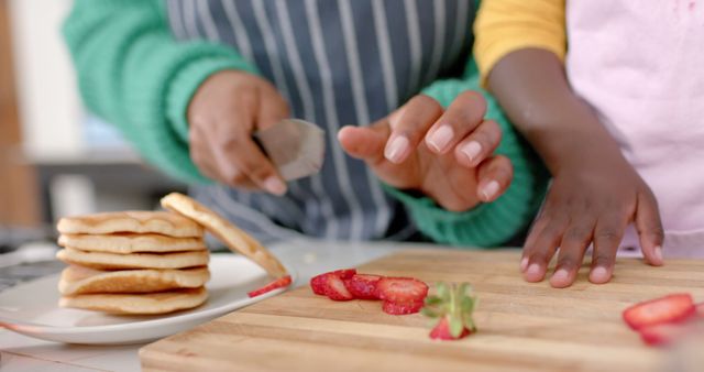 Parent and Child Preparing Pancakes and Strawberries in Kitchen - Download Free Stock Images Pikwizard.com