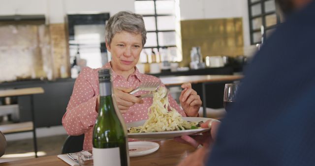 Mature Woman Enjoying Pasta at Trendy Restaurant - Download Free Stock Images Pikwizard.com