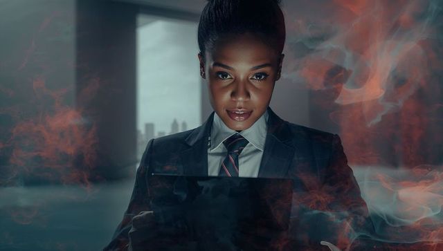 Focused Executive Working in Dimly Lit Office Enveloped in Red Smoke