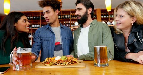 Diverse Friends Enjoying Bar Snack with Beer and Good Conversation