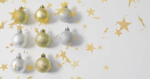Christmas Baubles with Glittering Golden Stars on White Surface