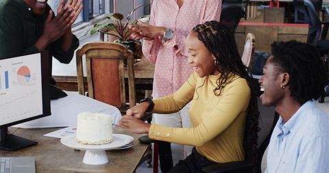 Diverse Team Celebrating Success with Cake in Office Meeting