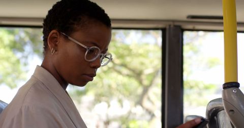 Young african female commuter using phone on bus ride