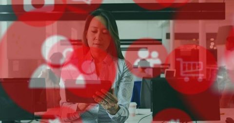 Asian woman holding tablet viewing red ui overlays in modern office, tech collaboration