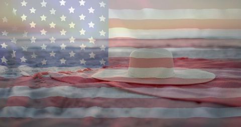 American Flag Overlaid on Sand with Hat and Towel
