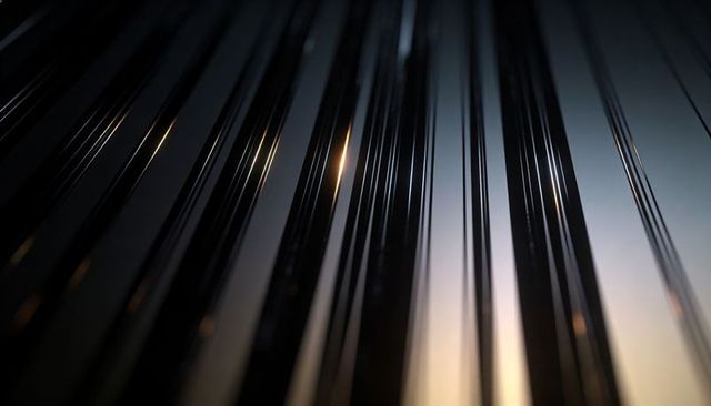 Shimmering vertical rods creating abstract minimalist background with warm bokeh