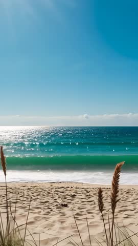 Vertical video opening on sandy beach with turquoise waves rolling and dune grasses swaying