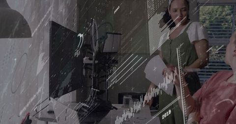Female colleagues reviewing data at home office with curved monitor and analytics overlay