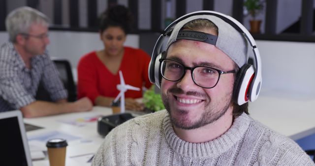 Young Professional in Office Wearing Headphones Working with Team - Download Free Stock Images Pikwizard.com