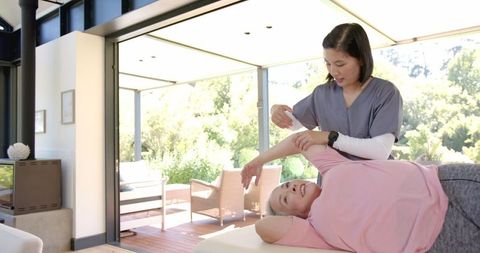 Senior Woman Receiving Arm Therapy from Physiotherapist at Home