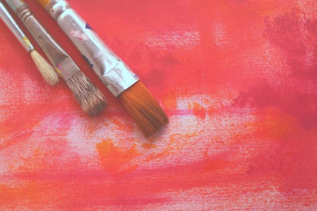 Close-Up of Paintbrushes on Colorful Red and Orange Canvas - Download Free Stock Photos Pikwizard.com