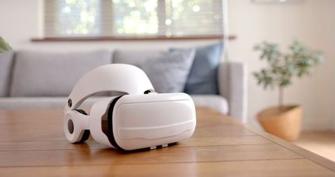 White virtual reality headset on wooden living room table