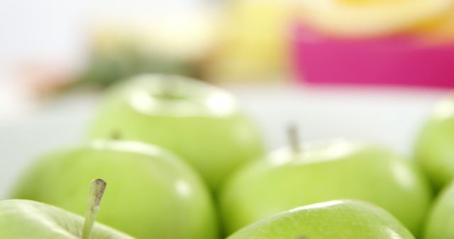 Close-up view of fresh green apples with soft focus in background. Ideal for topics related to healthy eating, nutrition, fresh produce, or organic food. Can be used for promotional materials, lifestyle blogs, health and diet articles, or food magazines.