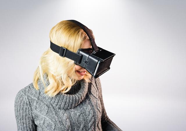 Happy woman using virtual reality headset against white background