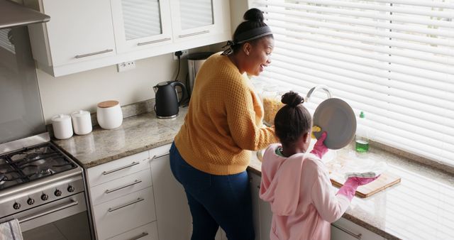 Mother and Daughter Washing Dishes in Sunlit Kitchen - Download Free Stock Images Pikwizard.com