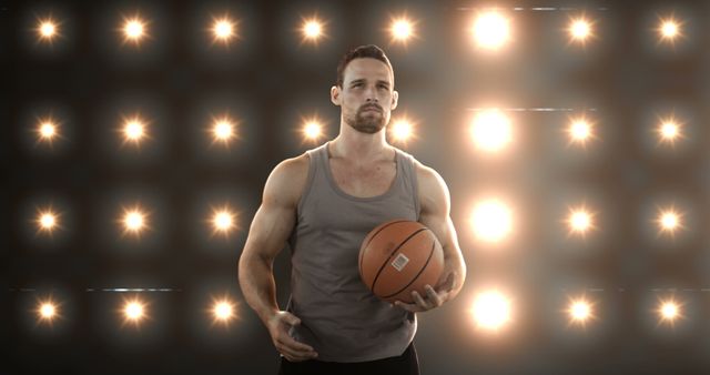 Confident Young Athlete Holding Basketball in Spotlight - Download Free Stock Images Pikwizard.com