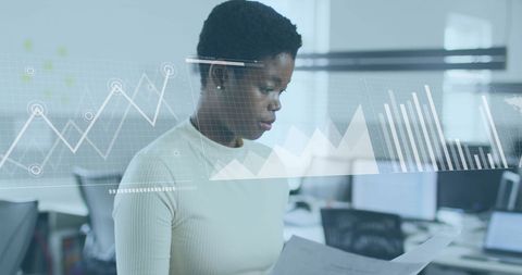 Businesswoman Analyzing Documents with Overlaid Data Charts