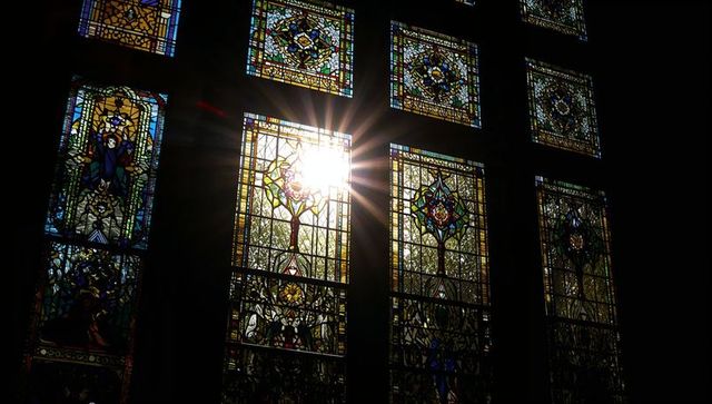 Sun Rays Through Stained Glass in Church Nave